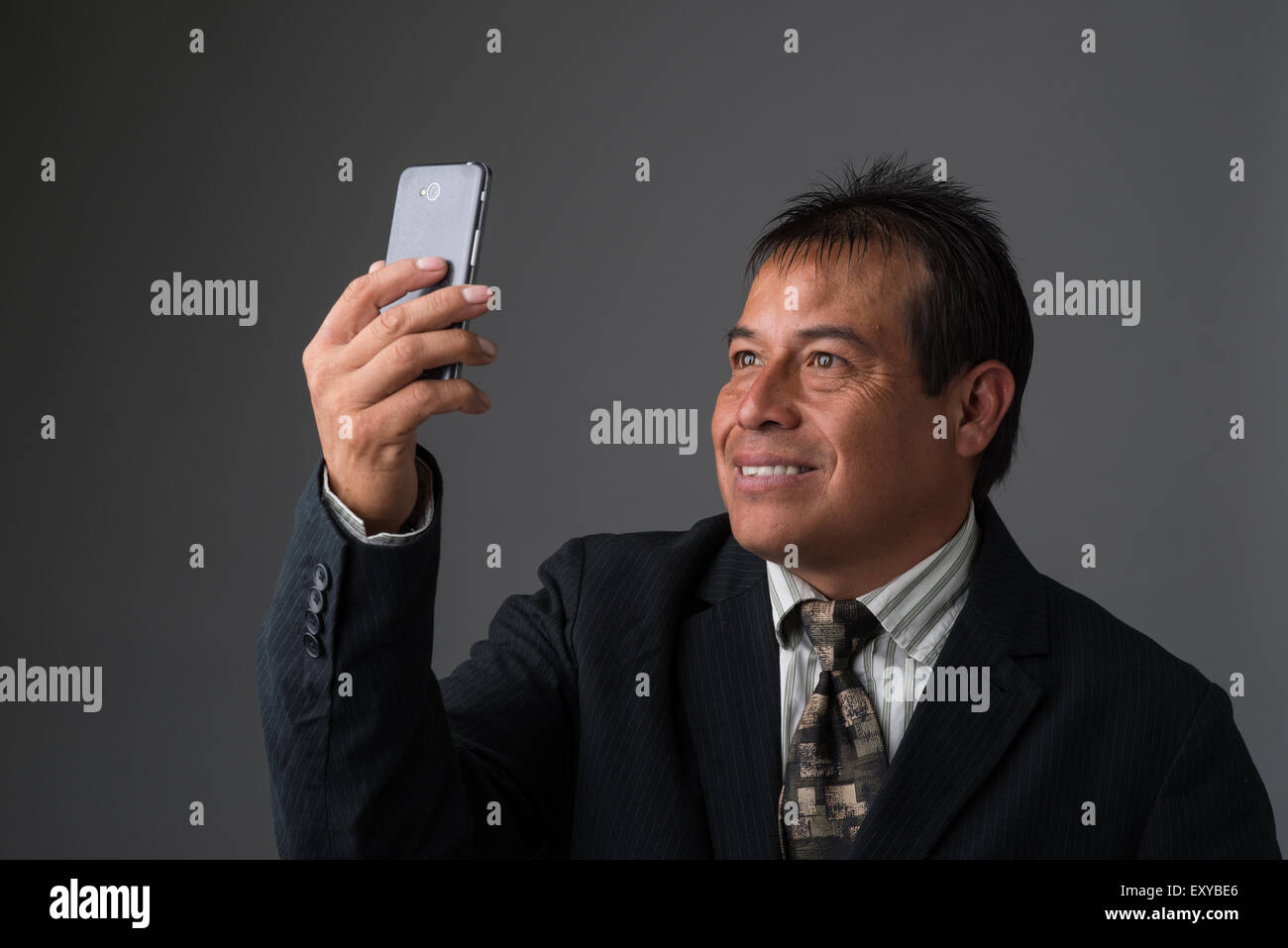 Hispanic Geschäftsmann halten, wobei ein Selbstporträt mit seinem Handy. Stockfoto