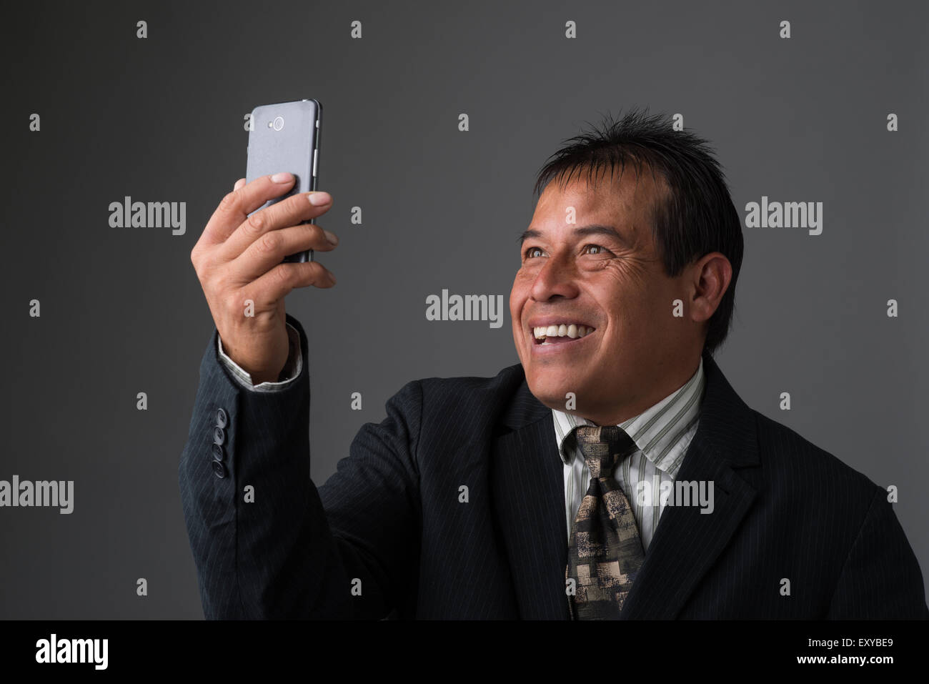 Hispanic Geschäftsmann halten, wobei ein Selbstporträt mit seinem Handy. Stockfoto