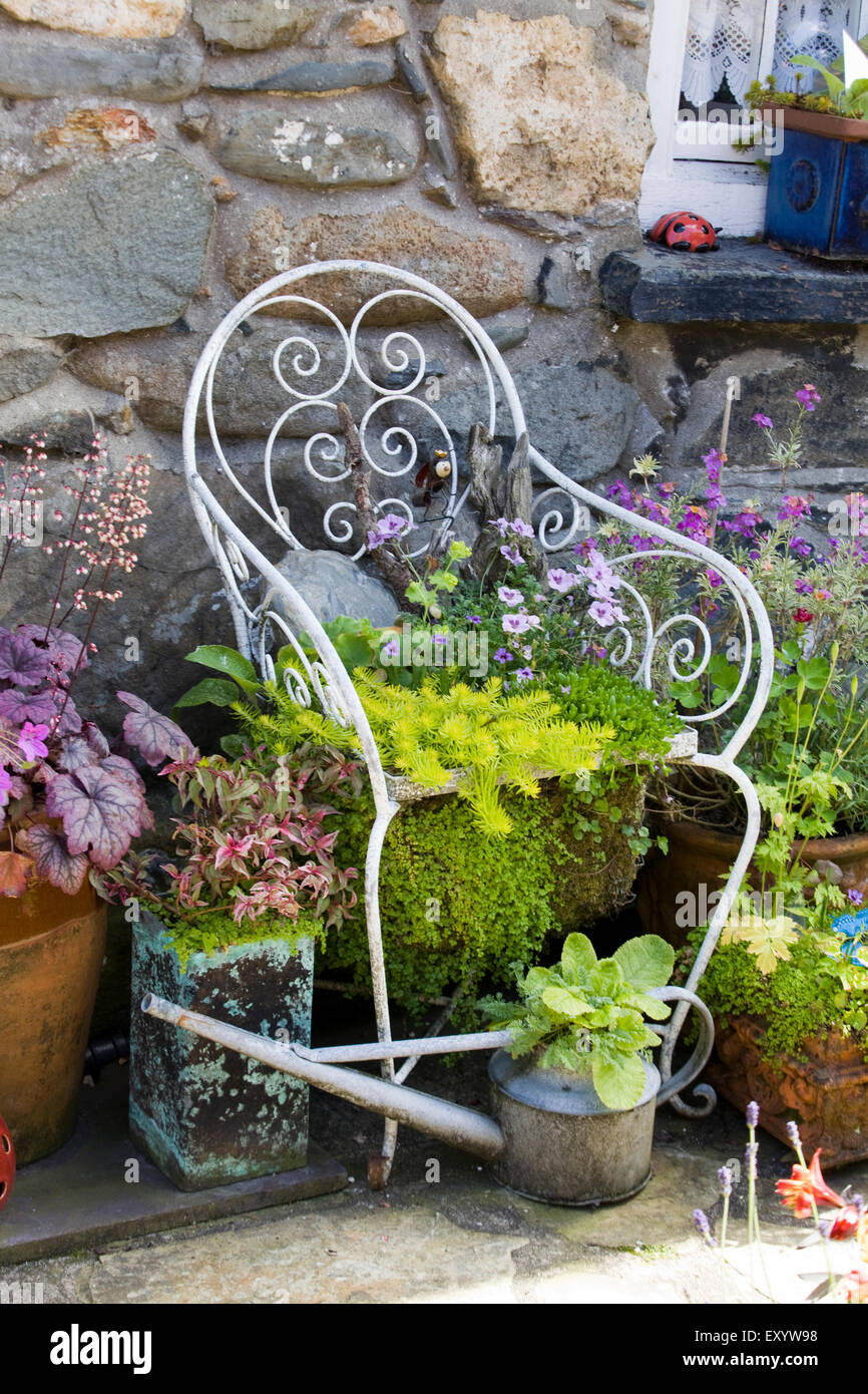 Gartenstuhl dekoriert in Blumen in einem Land-Haus-Garten Stockfotografie -  Alamy