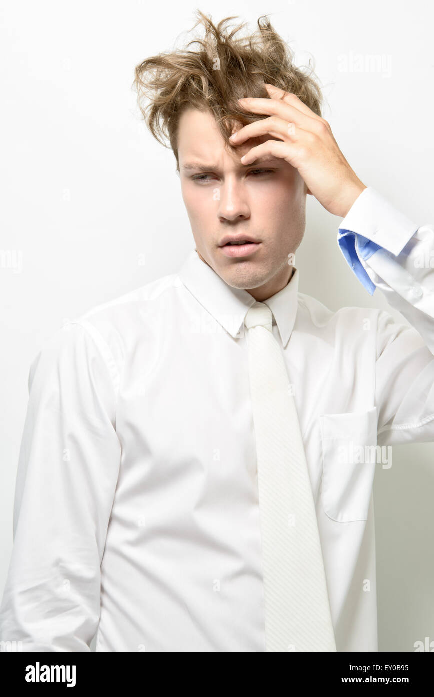 Ein hübscher junger Mann, männliches Model trägt ein weißes Hemd mit weißen Krawatte, posiert mit strubbeligem Haar. Stockfoto