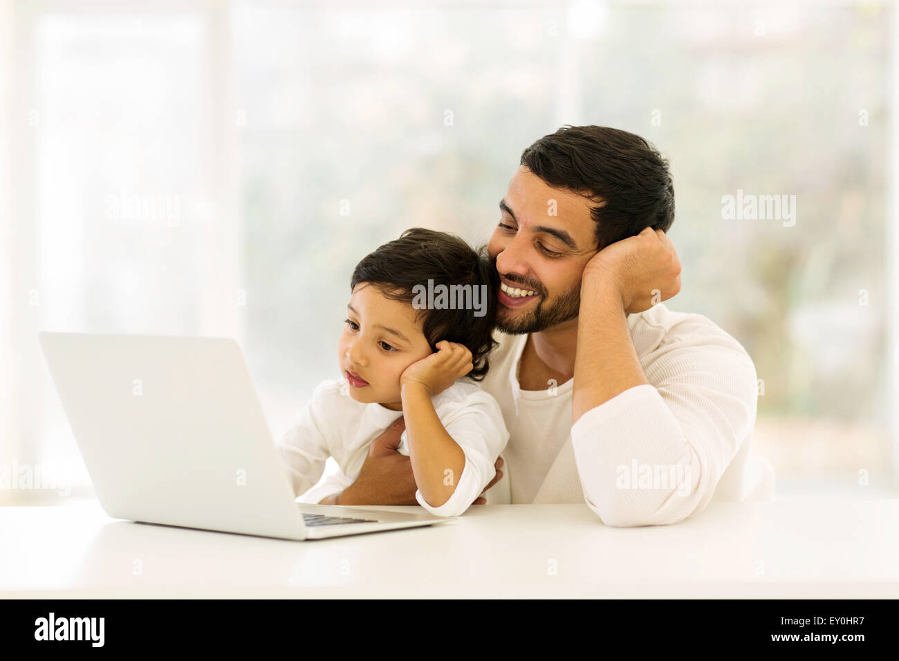 glücklicher Mann mit seinem kleinen Jungen zu Hause entspannen und mit laptop Stockfoto