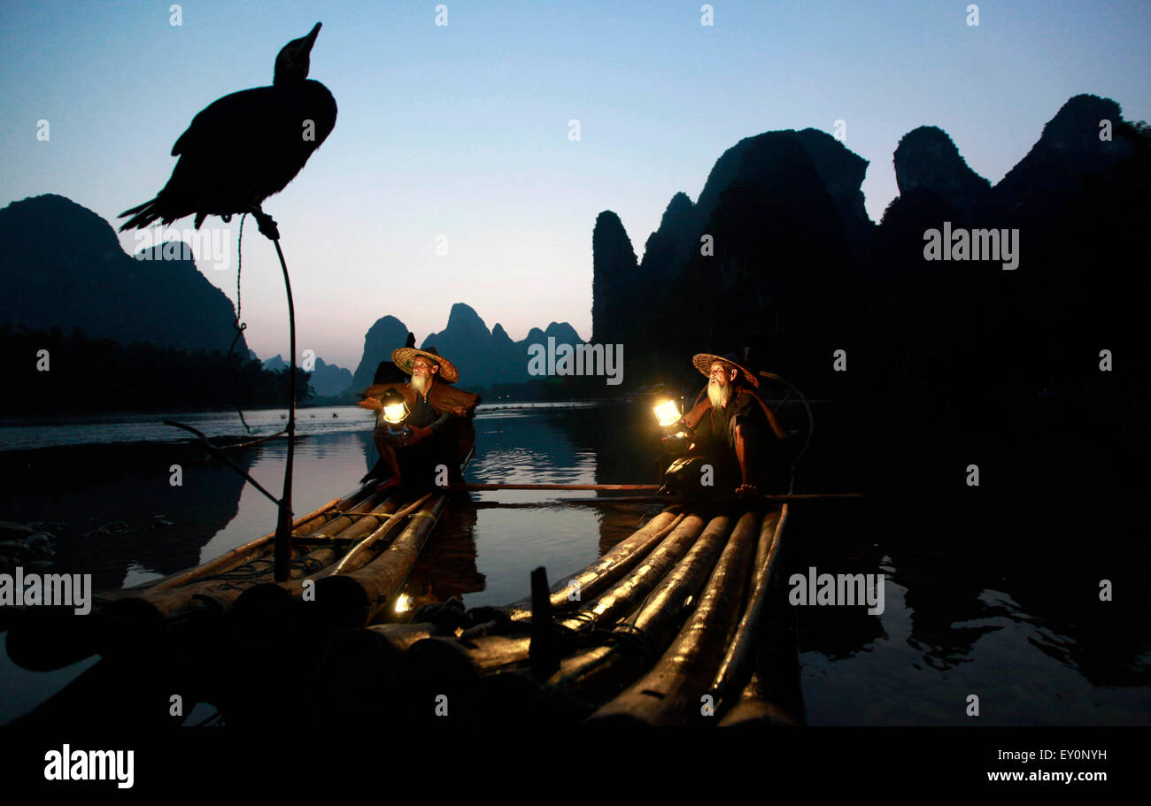 Peking, China der Provinz Guangxi. 15. Juli 2015. Zwei Brüder in den 70er und 80er Jahre, arbeitet als Fotograf der Modelle machen Sie eine Pause auf einem Bambusfloß in Lijiang Fluss von Guilin, Guangxi Provinz Süd-China, 15. Juli 2015. © Liu Jiaoqing/Xinhua/Alamy Live-Nachrichten Stockfoto