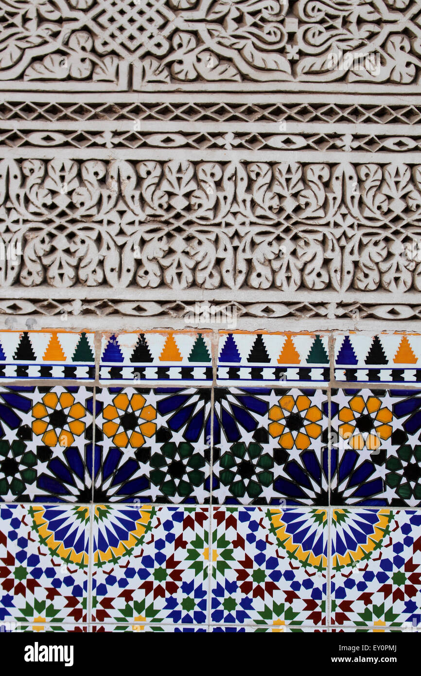 Arabesque Stuck gehauene Wand Detail mit Keramikfliesen, die in Marrakesch, Marokko Stockfoto