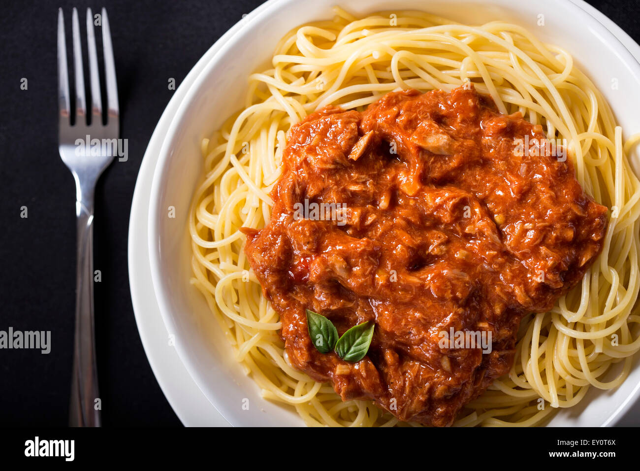 Spaghetti mit Thunfisch-Sauce auf schwarzem Hintergrund Stockfoto