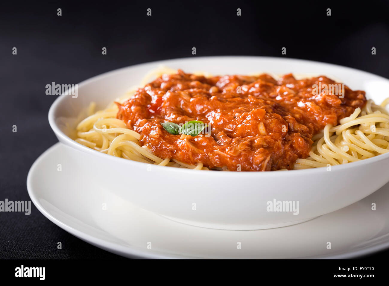 Spaghetti mit Thunfisch-Sauce auf schwarzem Hintergrund Stockfoto