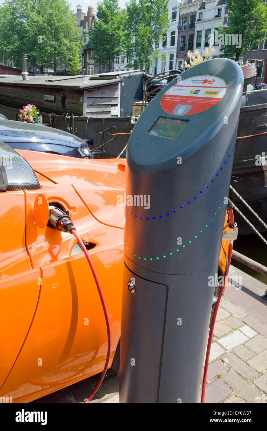 Orange Tesla Elektroauto aufladen Batterie am Straßenrand Amsterdam Holland Stockfoto