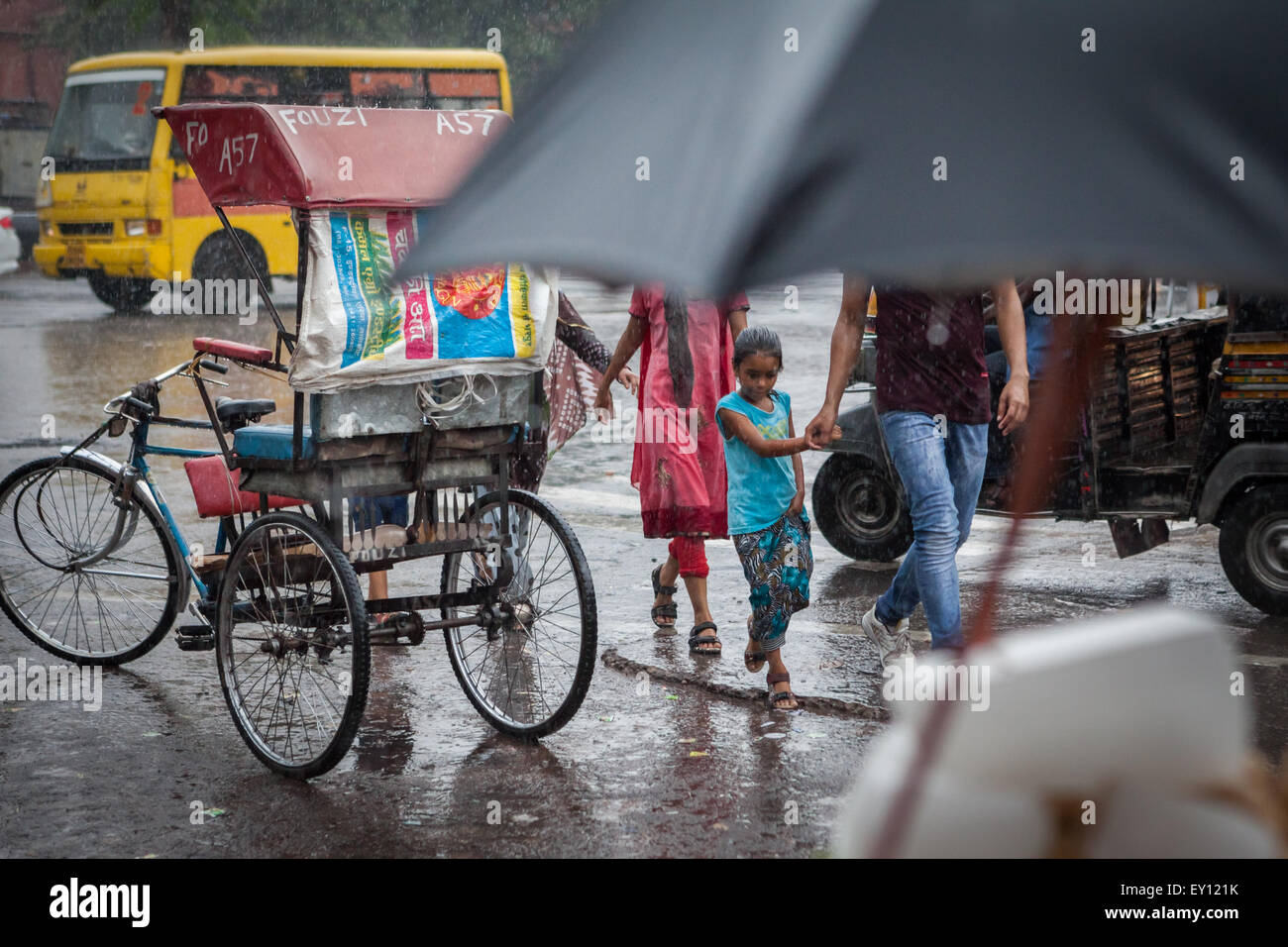 Eine Familie zu Fuß auf der Straße an einem regnerischen Tag in Jaipur, Rajasthan, Indien. Stockfoto