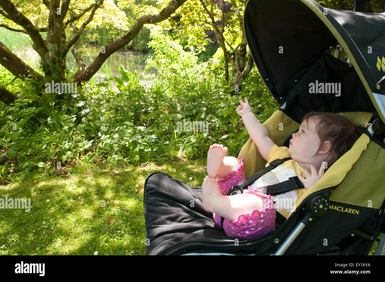 Babymädchen in ihrem Kinderwagen im Freien zeigen Stockfoto