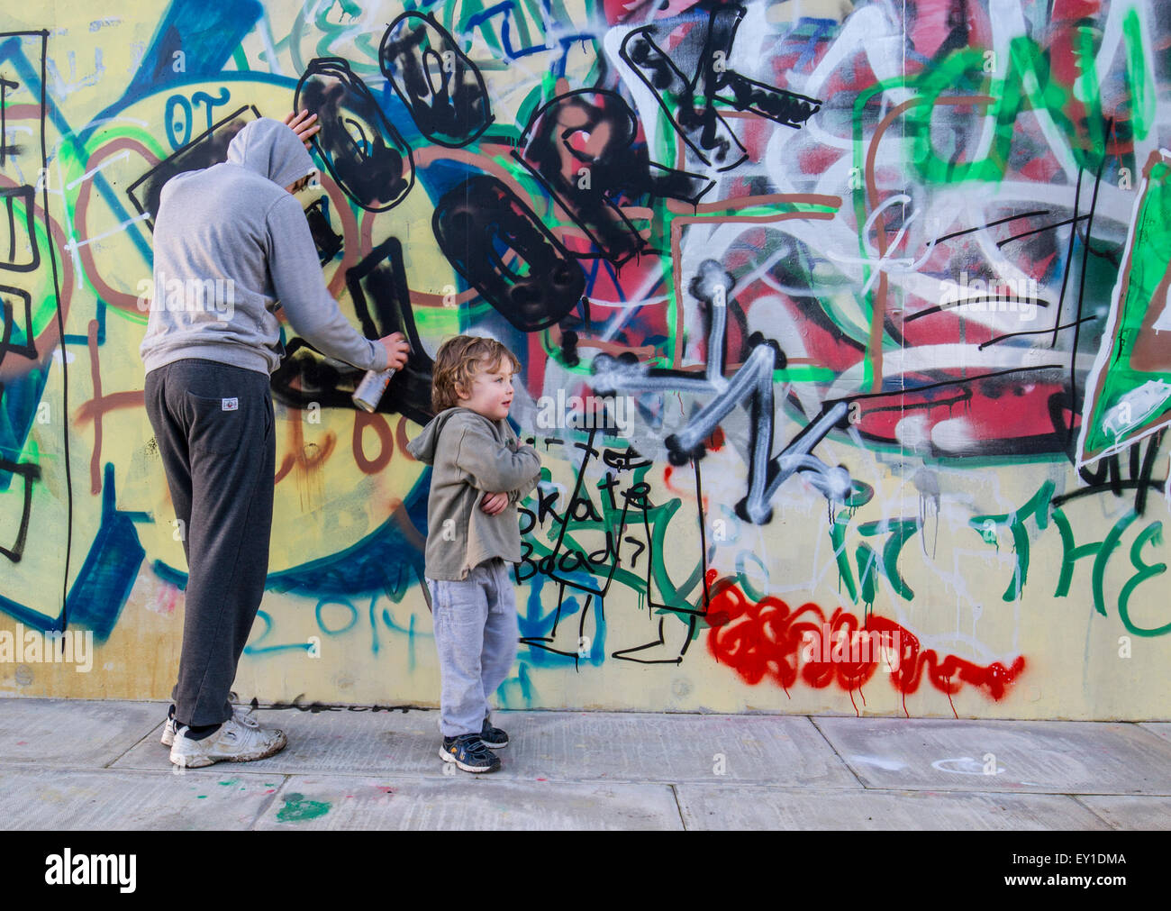 Hoody sprühen Graffiti an Wand mit jungen teen Stockfoto