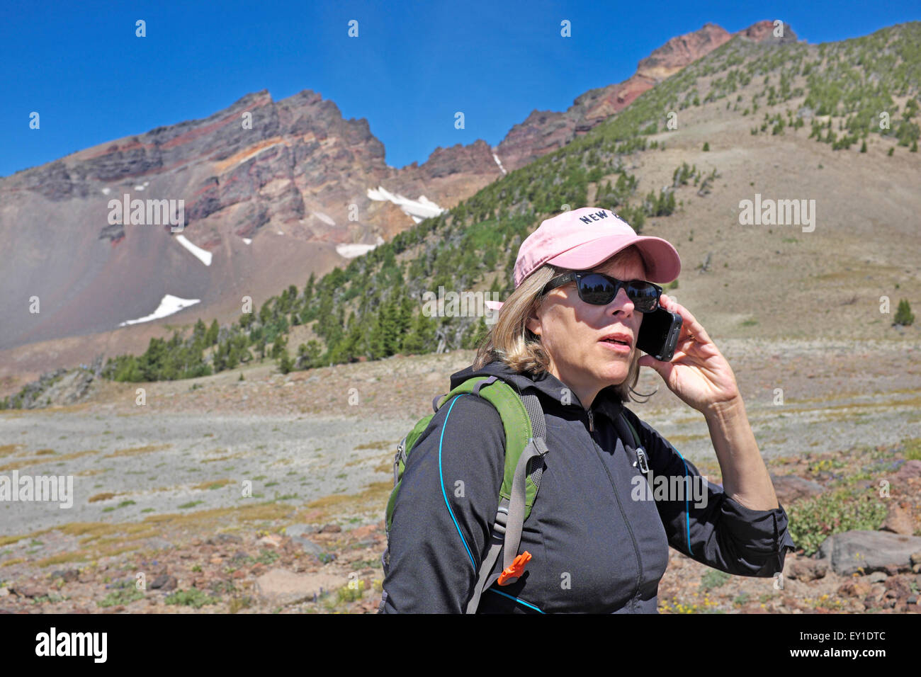 Eine weibliche Wanderer in der Wüste, im Gespräch mit jemand auf ihrem Handy. Stockfoto