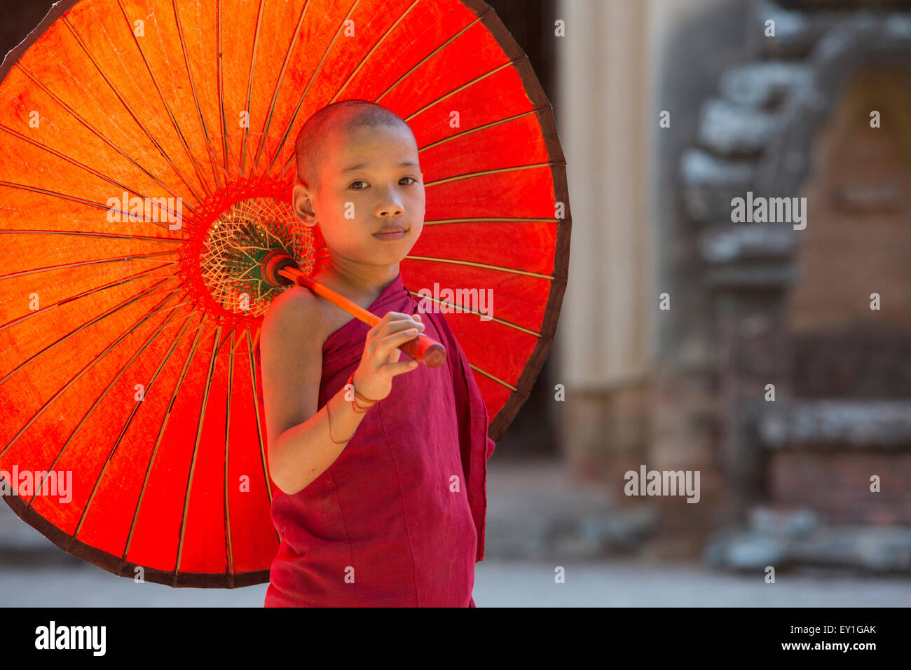 Buddhistischer Novize hält Regenschirm am Eingang, Sulamani Tempel, Myanmar Stockfoto