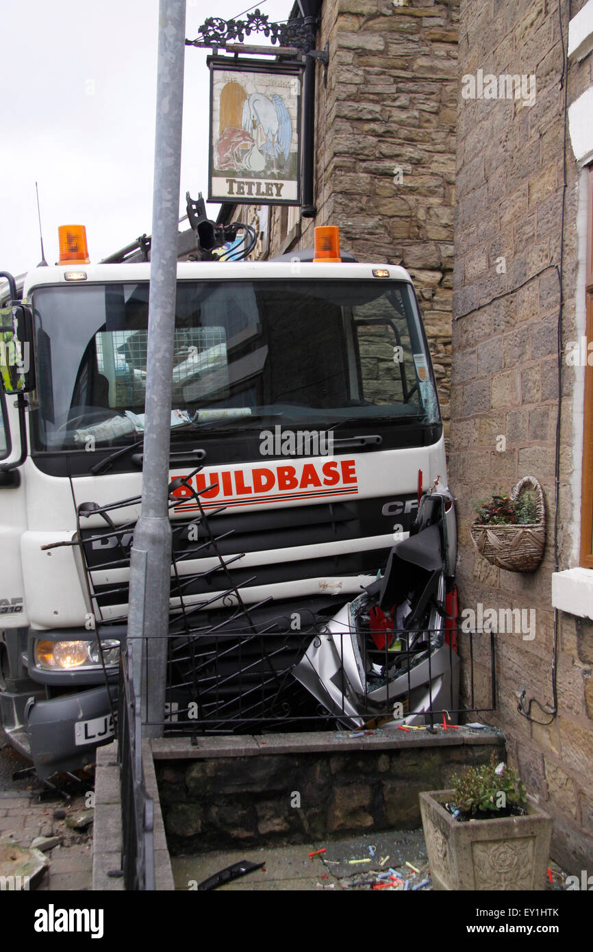 LKW beladen mit schweren Bau Materialien Reittiere der Fahrbahn stürzt in ein Wirtshaus und Zerkleinern von einem geparkten Auto in Großbritannien Stockfoto