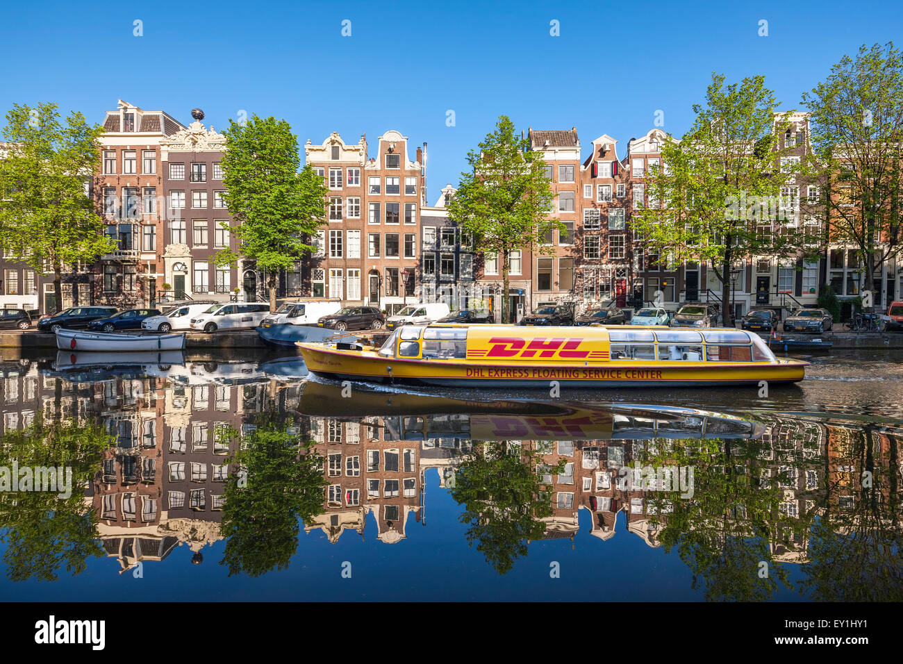 Amsterdam Singel Gracht mit DHL Lieferung Kanalboot im frühen Morgen im Sommer. Stockfoto