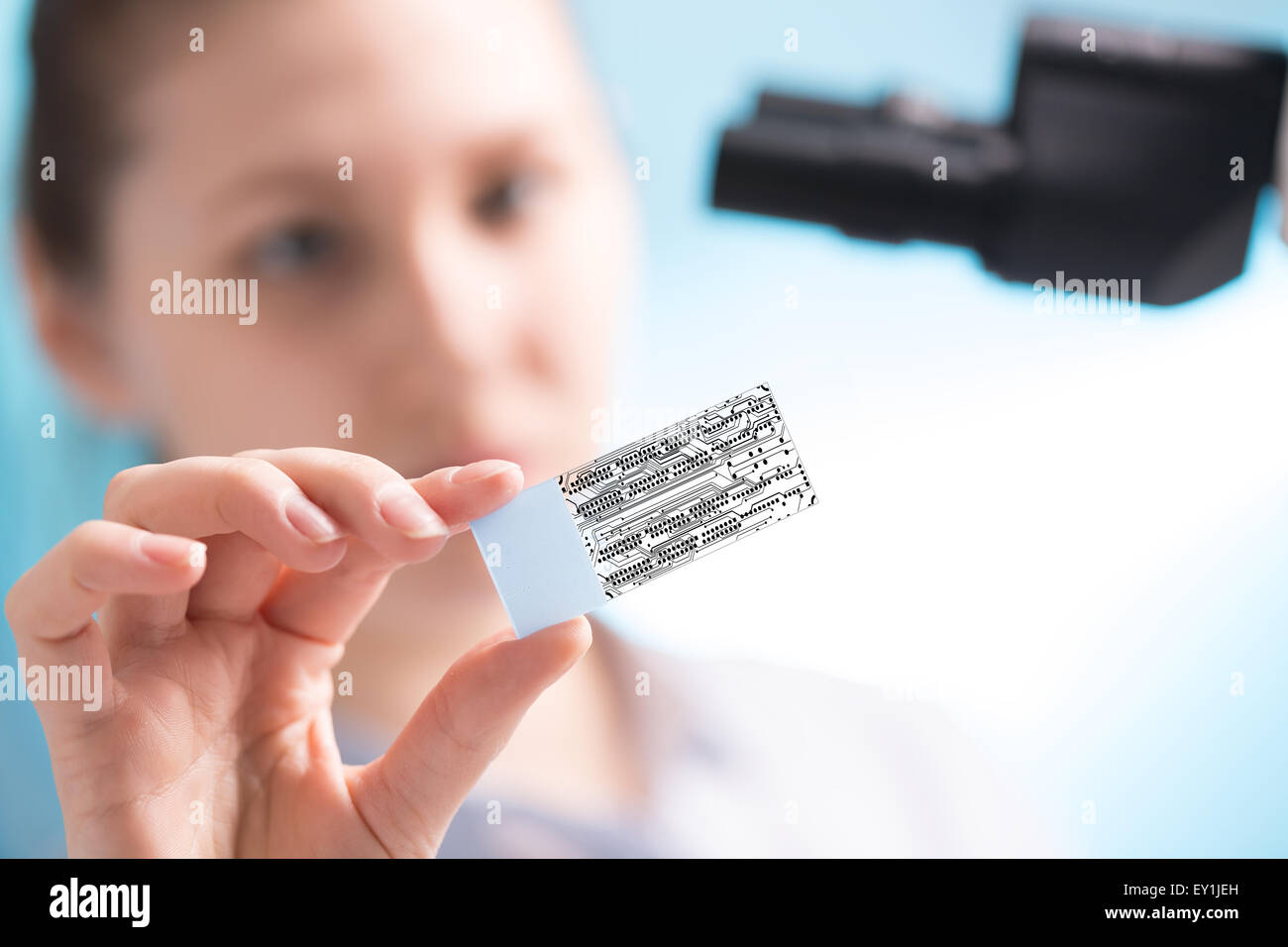 Im Labor schaut Techniker Dias durch einen Mikrochip Stockfoto