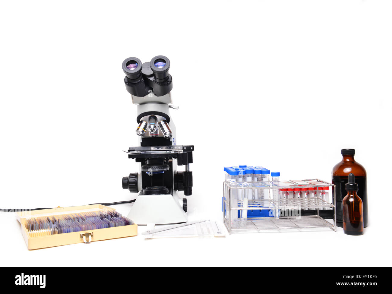 Mikroskop mit Laborgeräten auf weißem Hintergrund Stockfoto