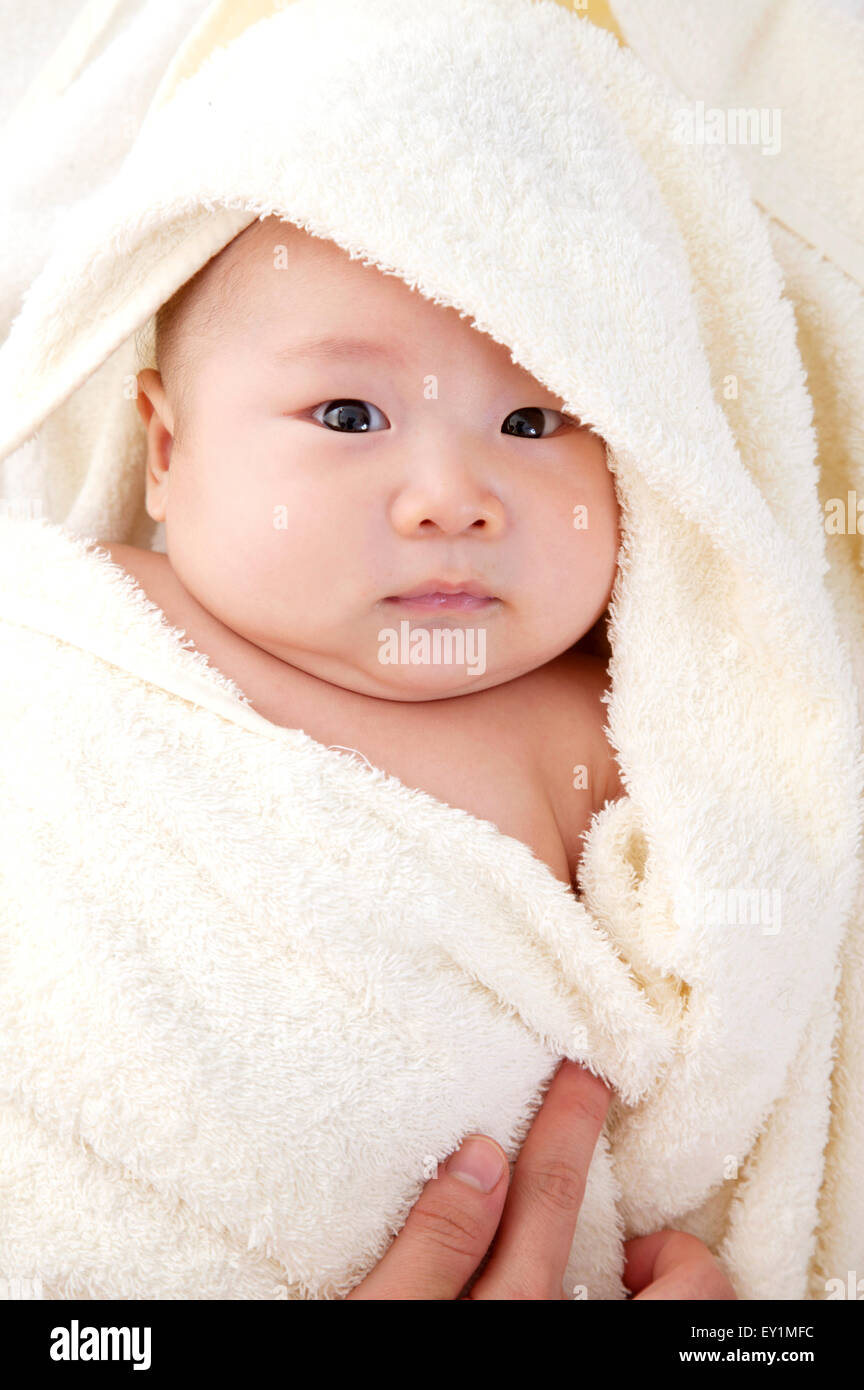 Baby Junge in eine Decke gewickelt und in die Kamera schaut, Stockfoto