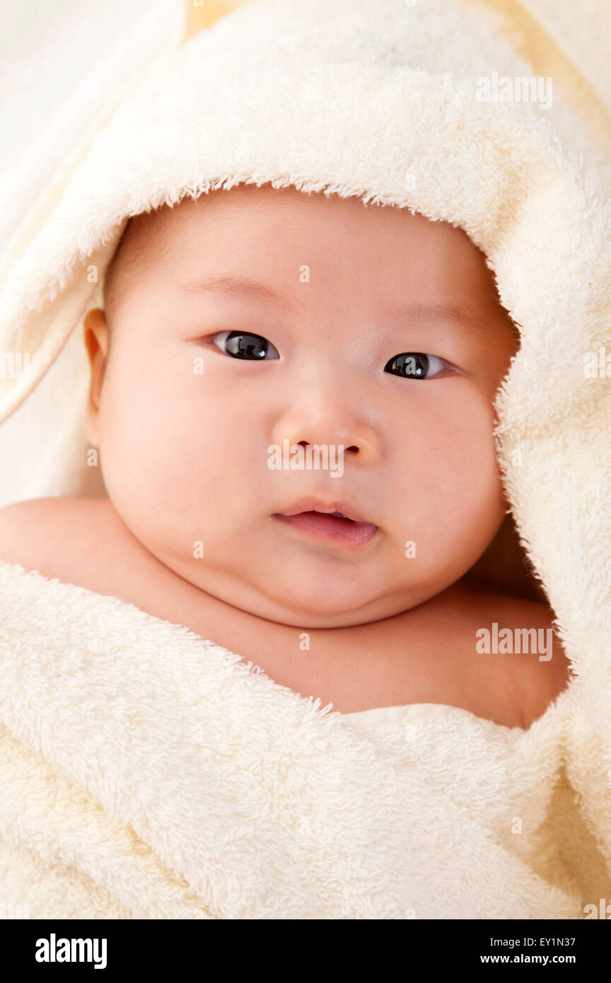 Baby Junge in eine Decke gewickelt und in die Kamera schaut, Stockfoto