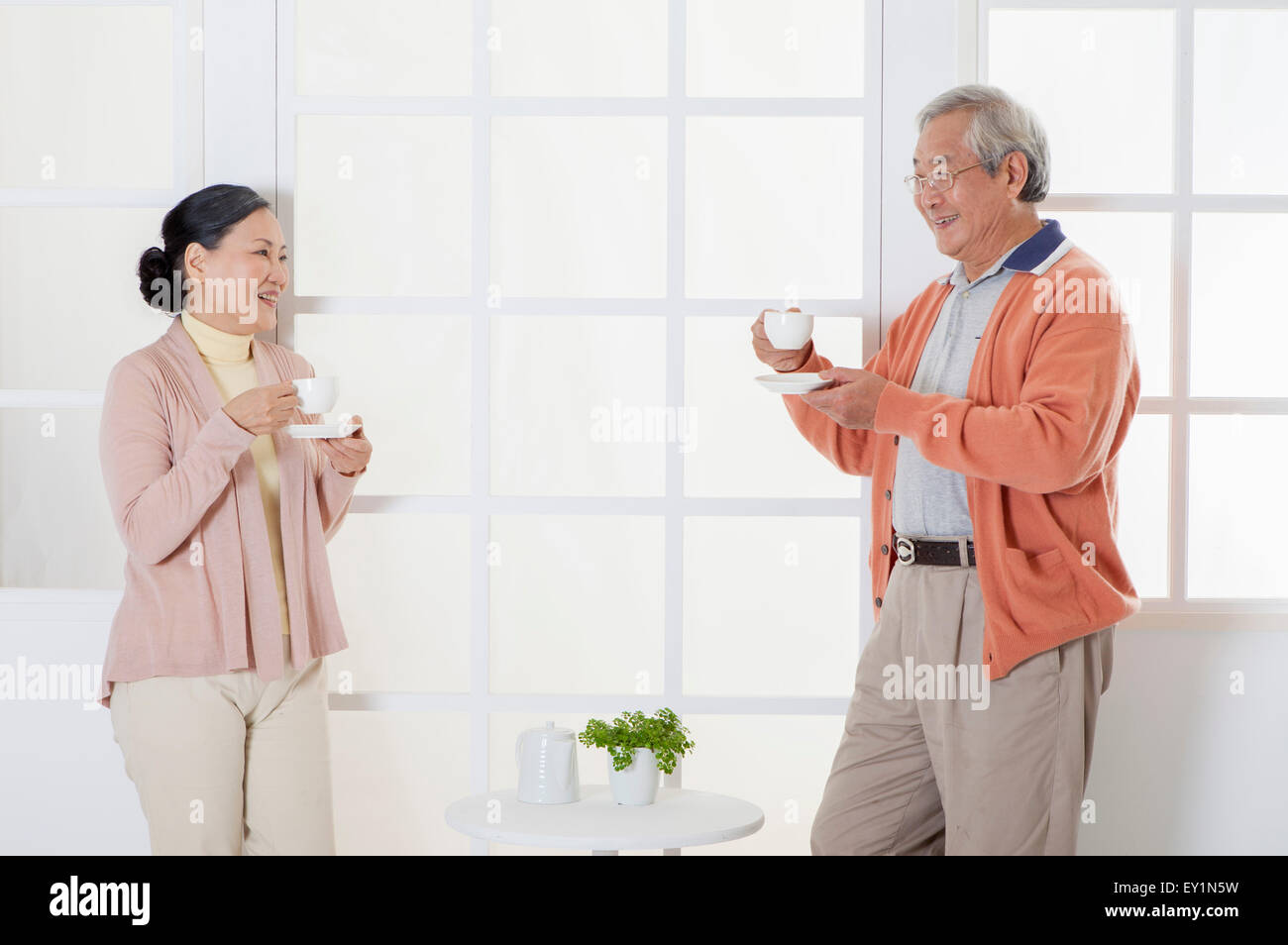 Älteres Paar hält eine Tasse trinken und Lächeln einander an, Stockfoto