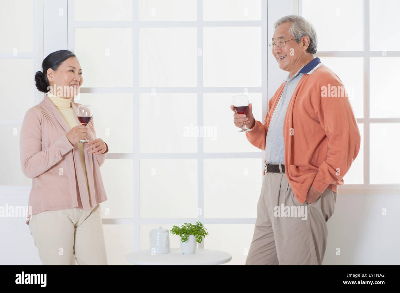 Älteres Paar mit einem Glas Rotwein und wegsehen, Stockfoto