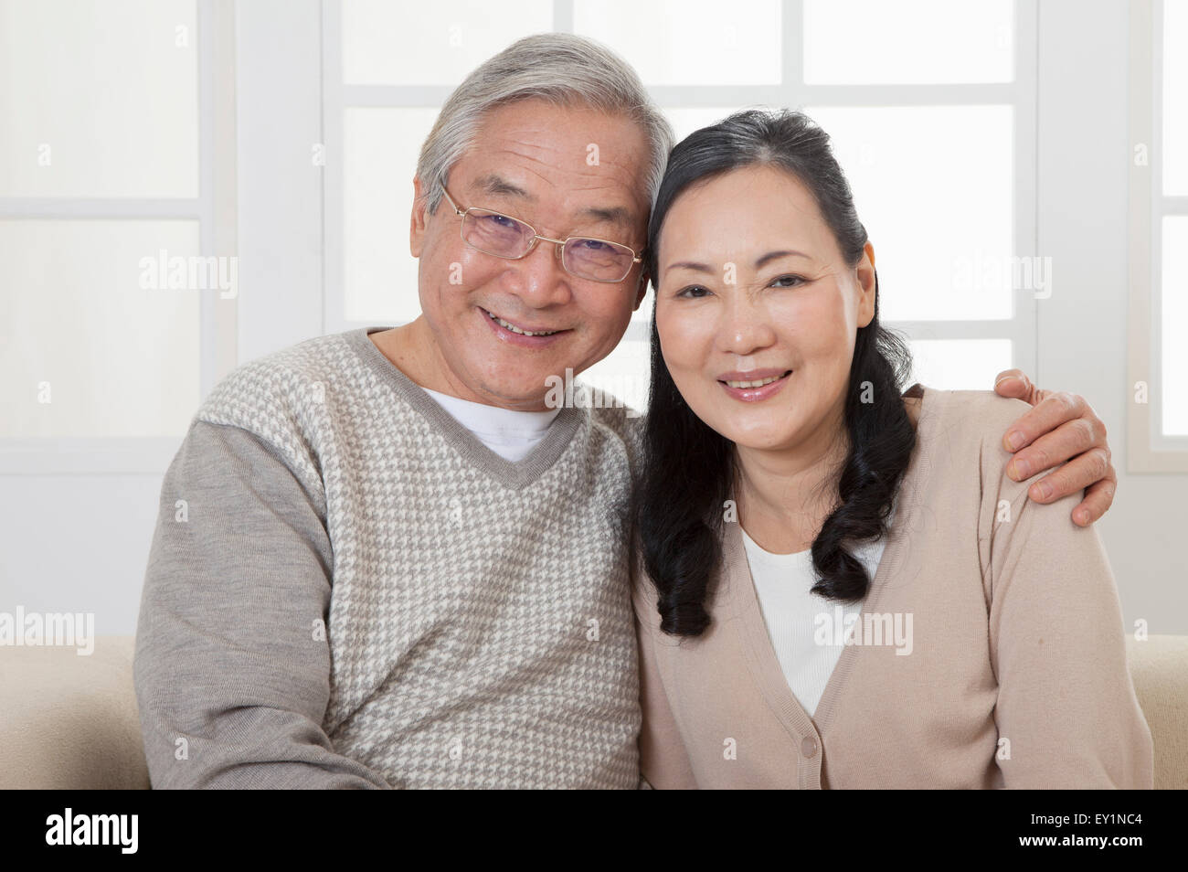 Älteres Paar glücklich lächelnd in die Kamera mit den Händen auf Schulter, Stockfoto
