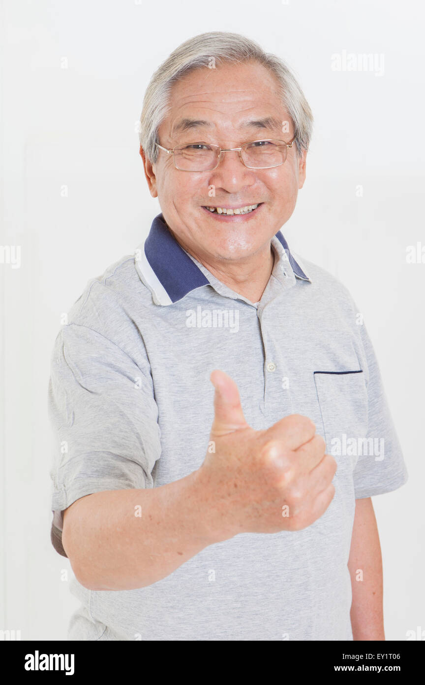 Ältere Mann lächelnd in die Kamera mit Daumen, Stockfoto