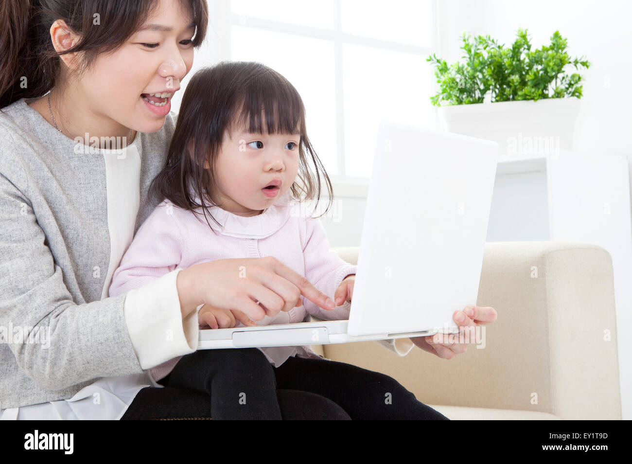 Mutter und Baby Mädchen Laptop zusammen zu spielen, Stockfoto