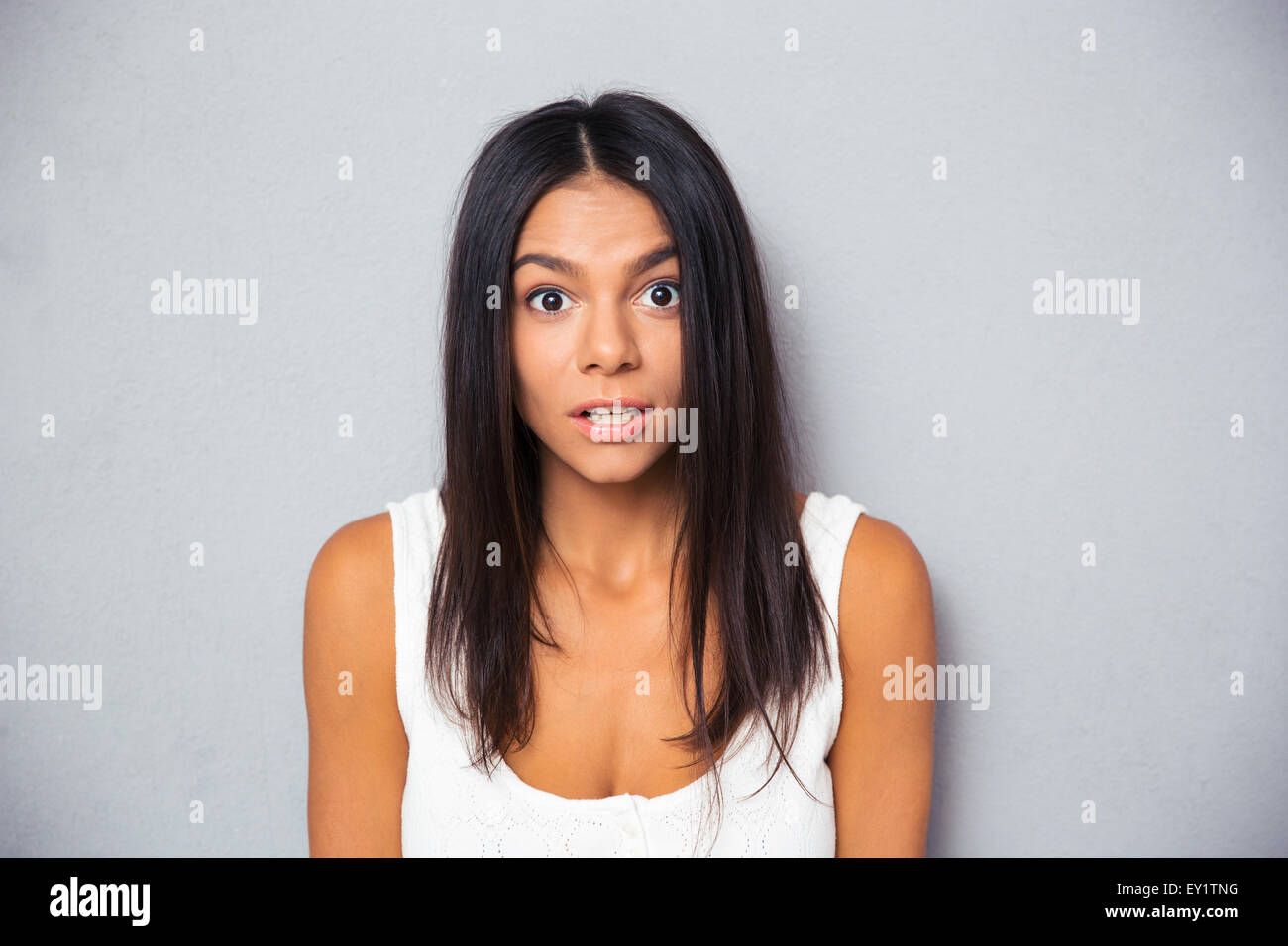 Porträt einer überrascht, jungen Frau auf grauem Hintergrund. Blick in die Kamera Stockfoto