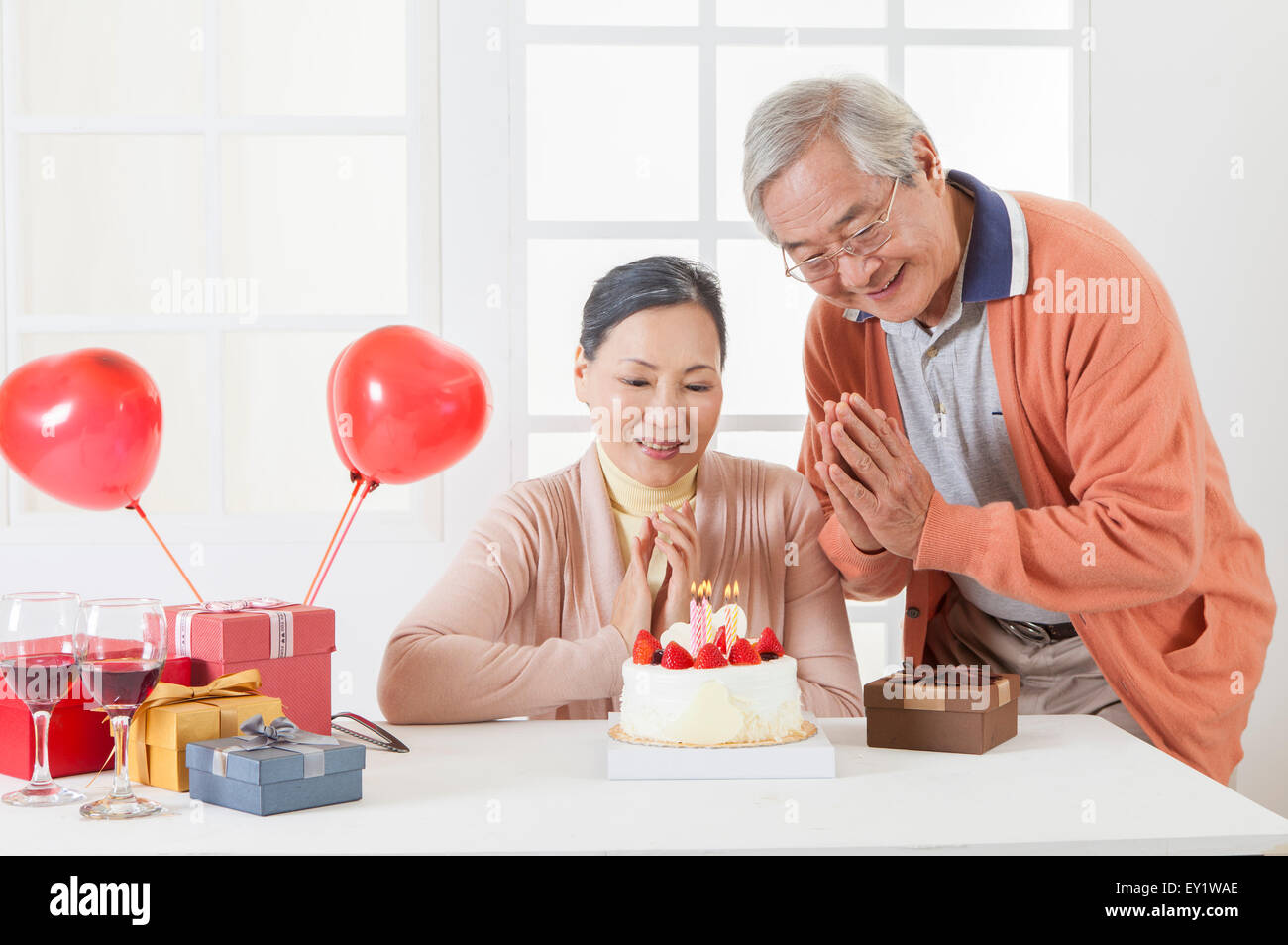 Älteres Paar feiert Geburtstag und glücklich lächelnd, Stockfoto
