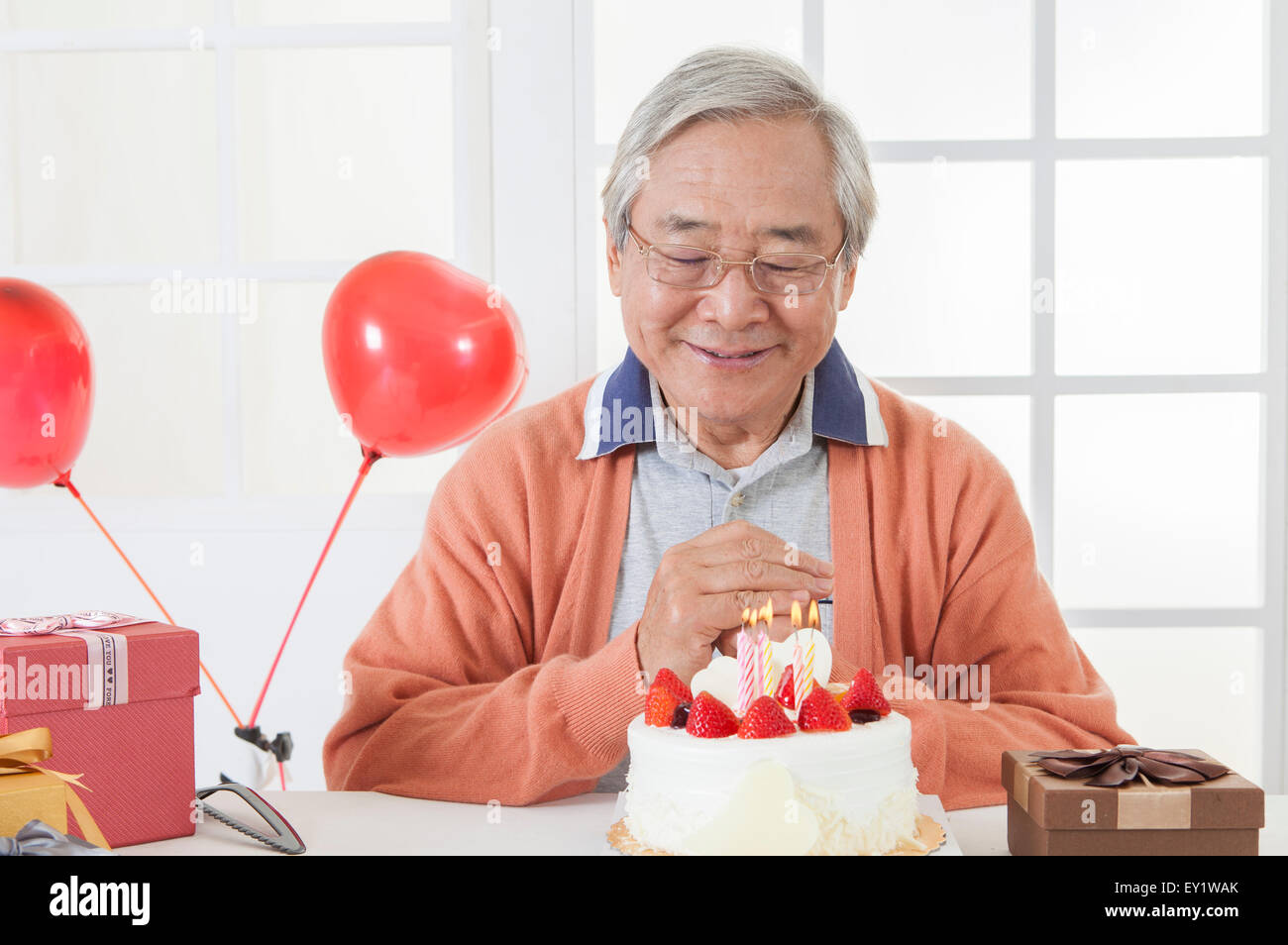 Senior woman feiert Geburtstag und wünschen mit Augen geschlossen, Stockfoto