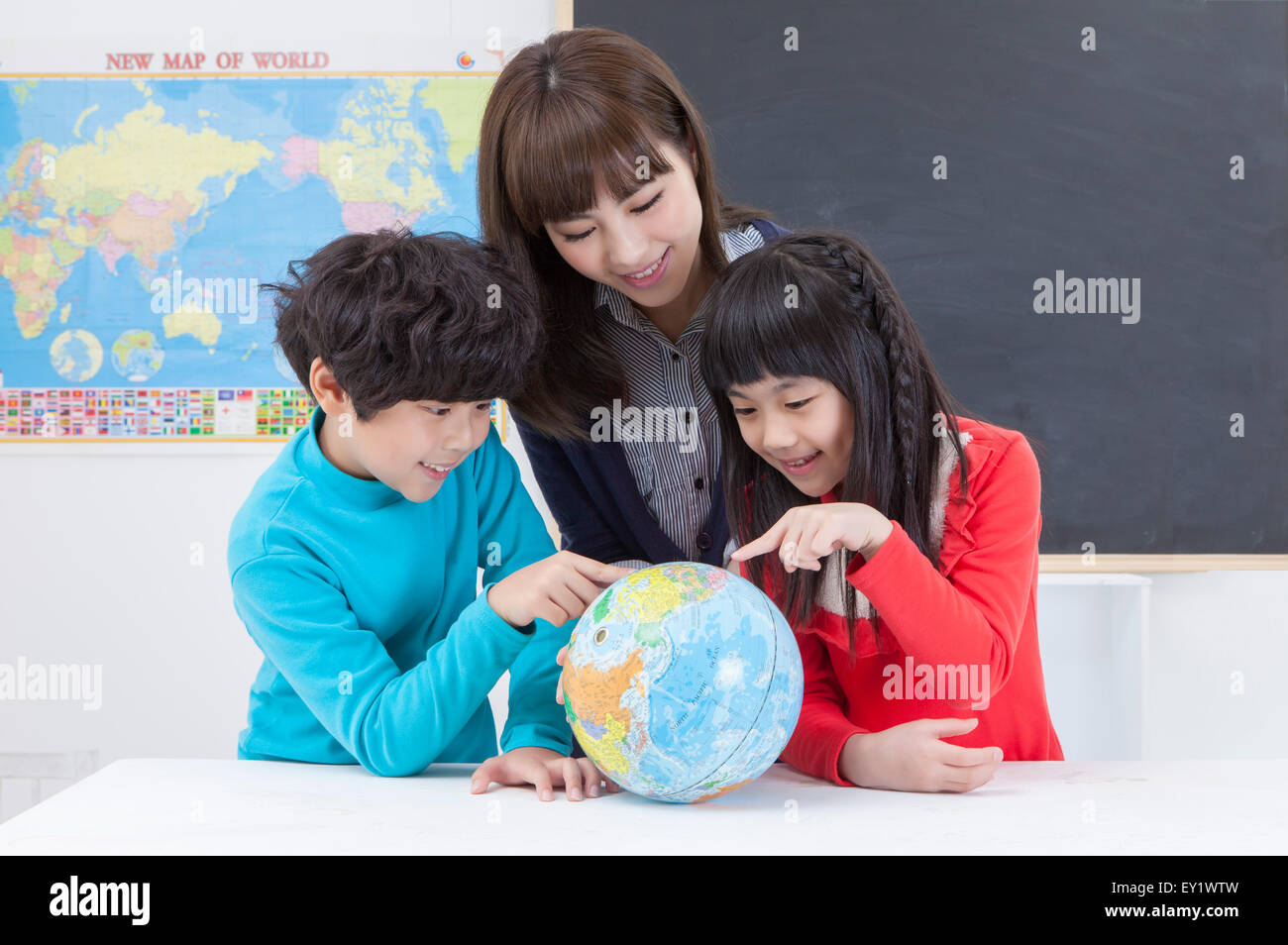 Junge Lehrer und Blick auf den Globus und studieren, Stockfoto