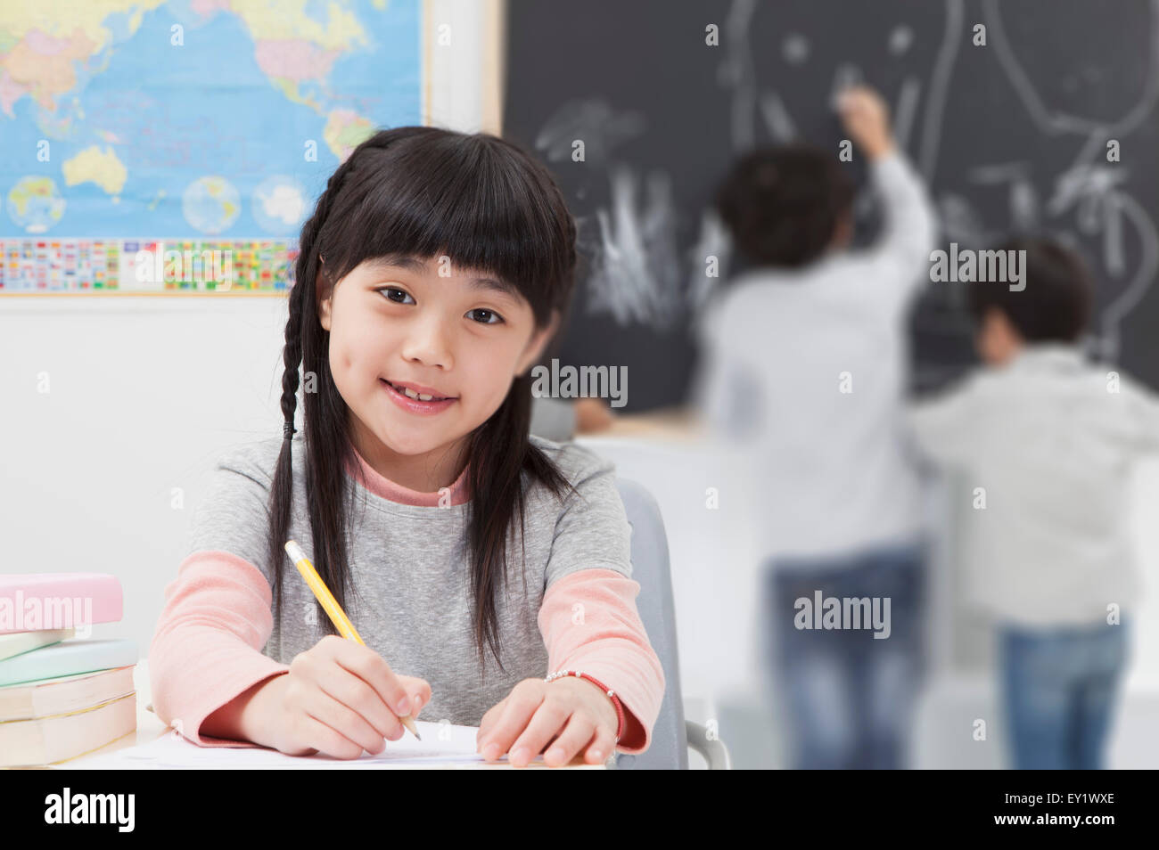 Mädchen in der Klasse sitzen und Lächeln in die Kamera, Stockfoto