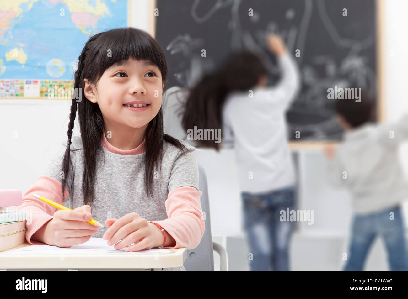 Kinder lernen im Klassenzimmer und wegschauen mit Lächeln, Stockfoto