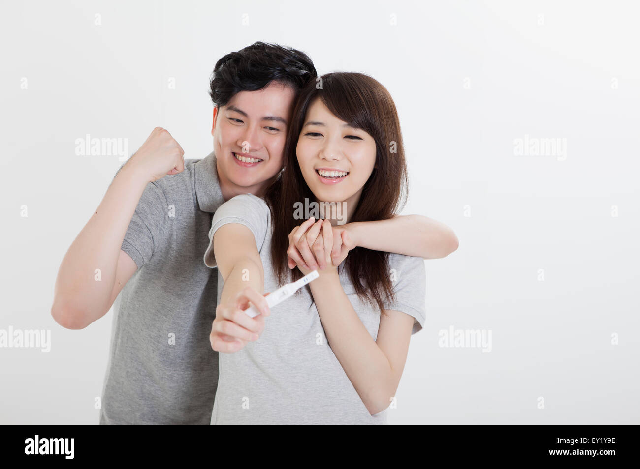 Junges Paar glücklich lächelnd mit Schwangerschaftstest Stick, Stockfoto