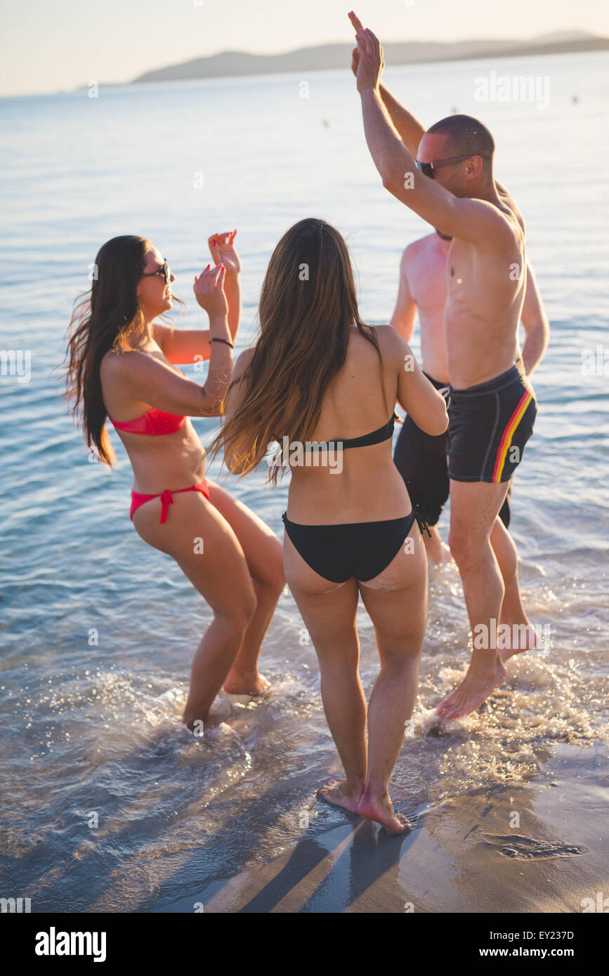 Gruppe von multiethnischen Jugendliche Frauen und Männer am Strand im Sommer springen und tanzen im Sonnenuntergang - Sorglosigkeit, Freundschaft-Konzepte Stockfoto