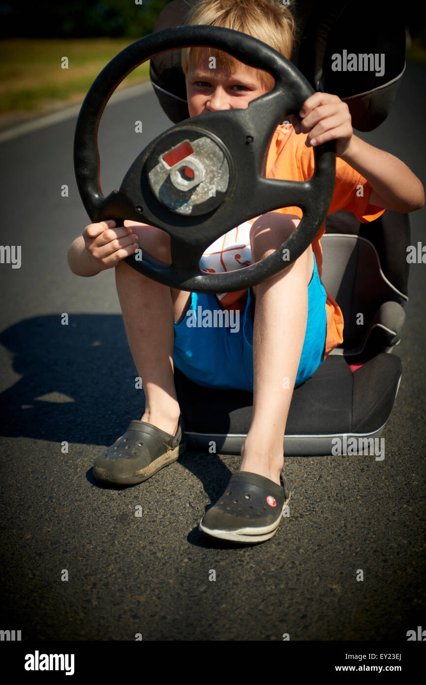 Treiber. Imaginäre Rennen. Kind junge imaginären Auto unterwegs mit Lenkrad Stockfoto