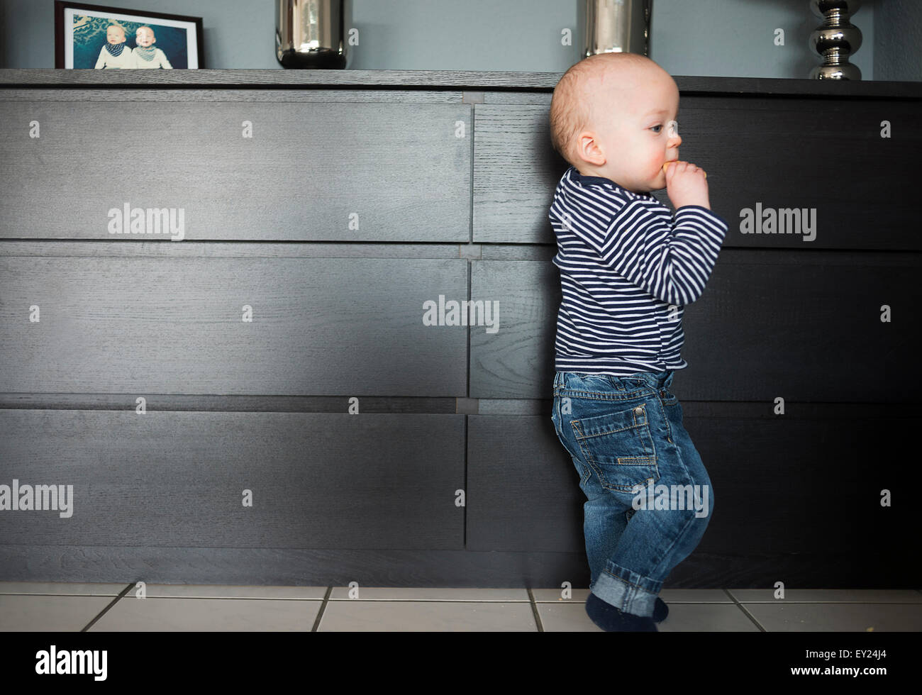 Baby Boy stützte sich auf Wohnzimmer sideboard Stockfoto