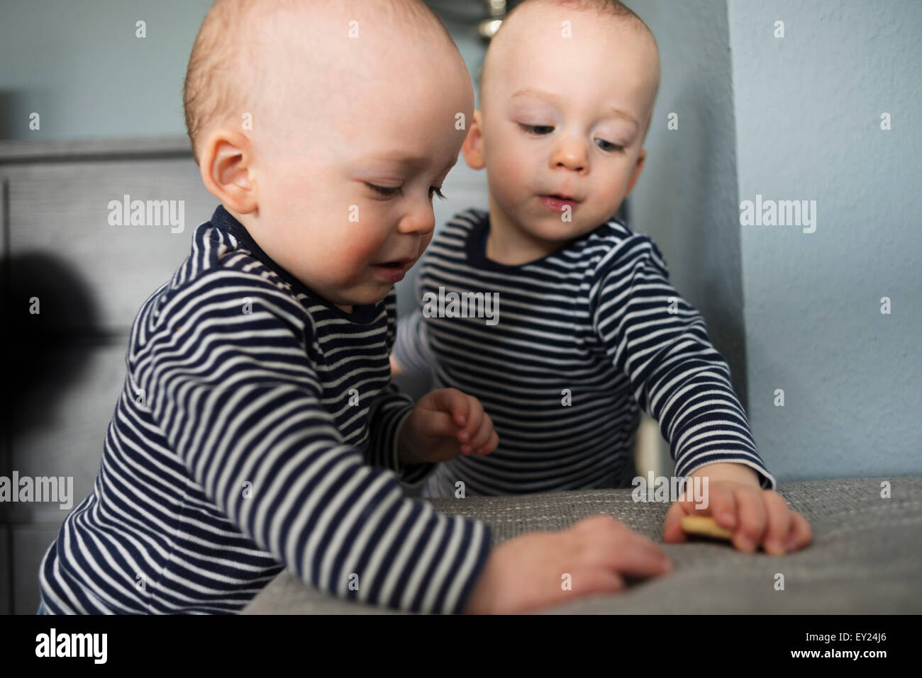 Baby Zwillinge spielen mit Keksen im Wohnzimmer Stockfoto