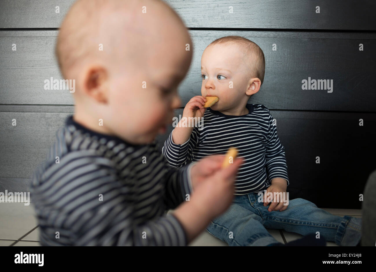 Baby Zwillinge essen Kekse im Wohnzimmer Stockfoto