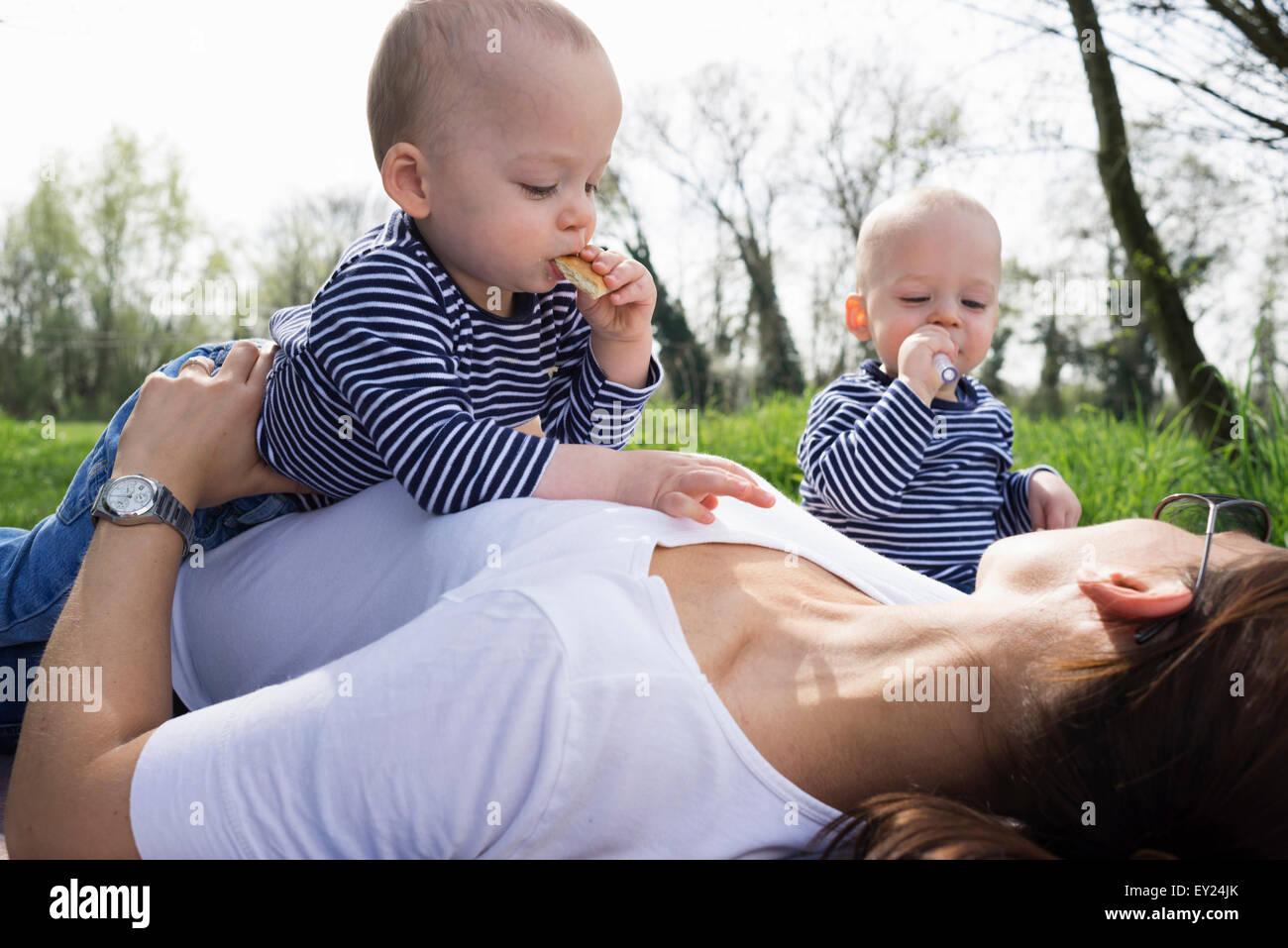 Baby Zwillinge und Mutter mit Picknick im Feld Stockfoto