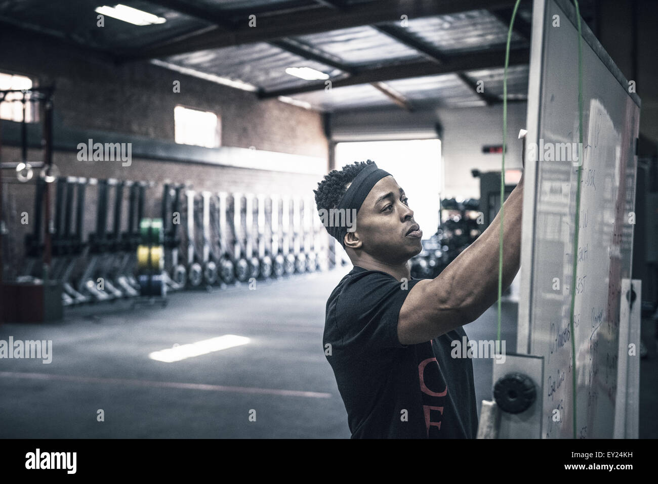 Junger Mann schreiben auf Whiteboards im Fitness-Studio Stockfoto