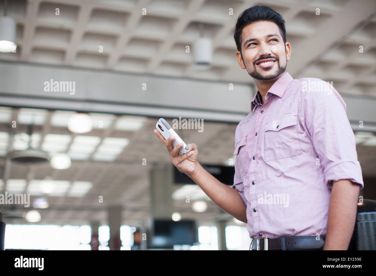 Niedrigen Winkel Blick des jungen Mannes mit Smartphone im Bahnhof Stockfoto