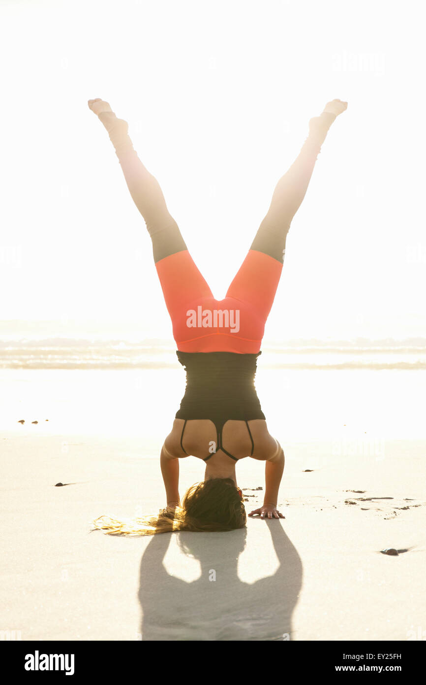 Frau in Yoga-Pose am Strand Stockfoto