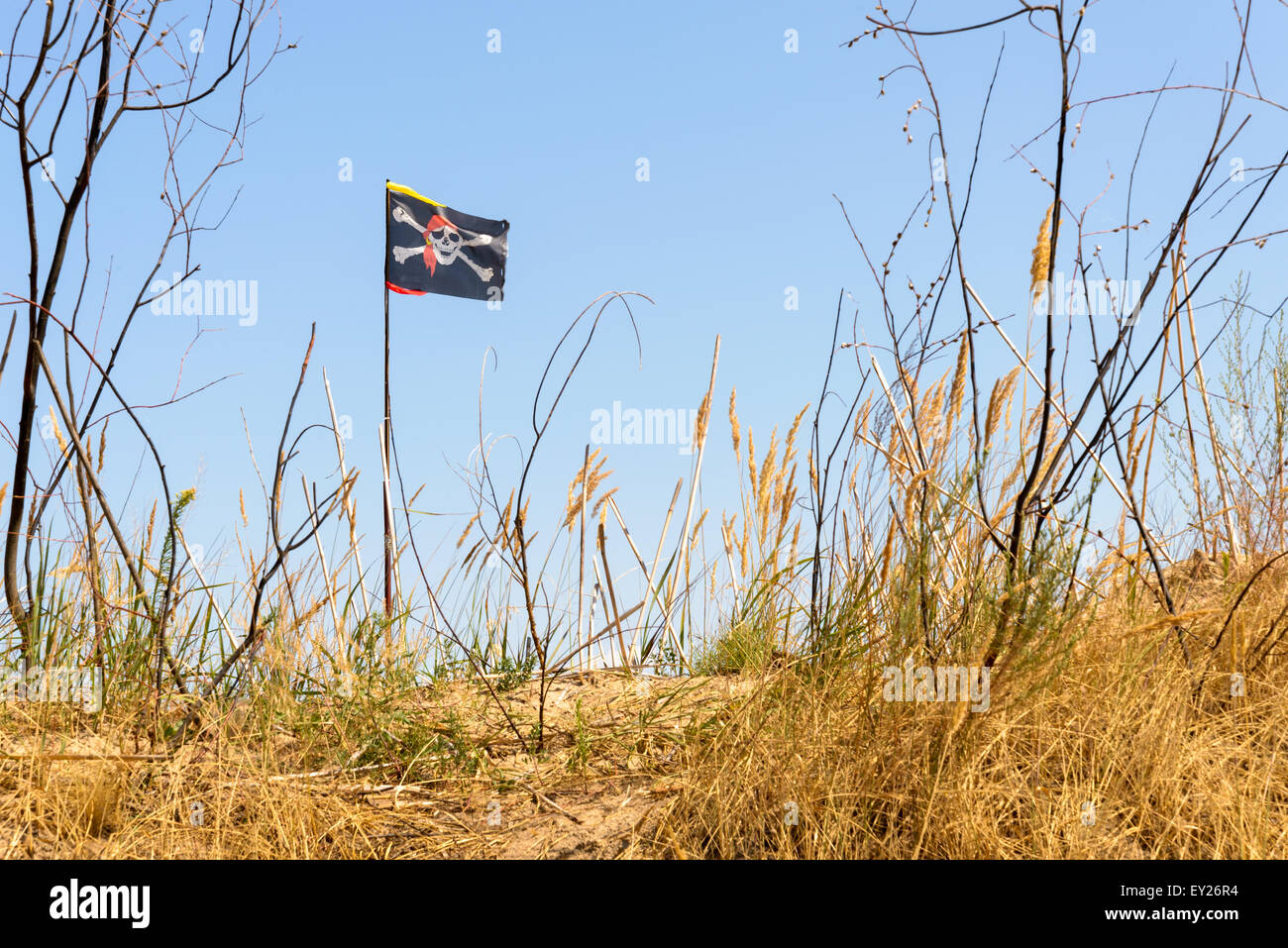 Die schwarze Piratenflagge Jolly Roger flattert im Wind über den Berg Stockfoto