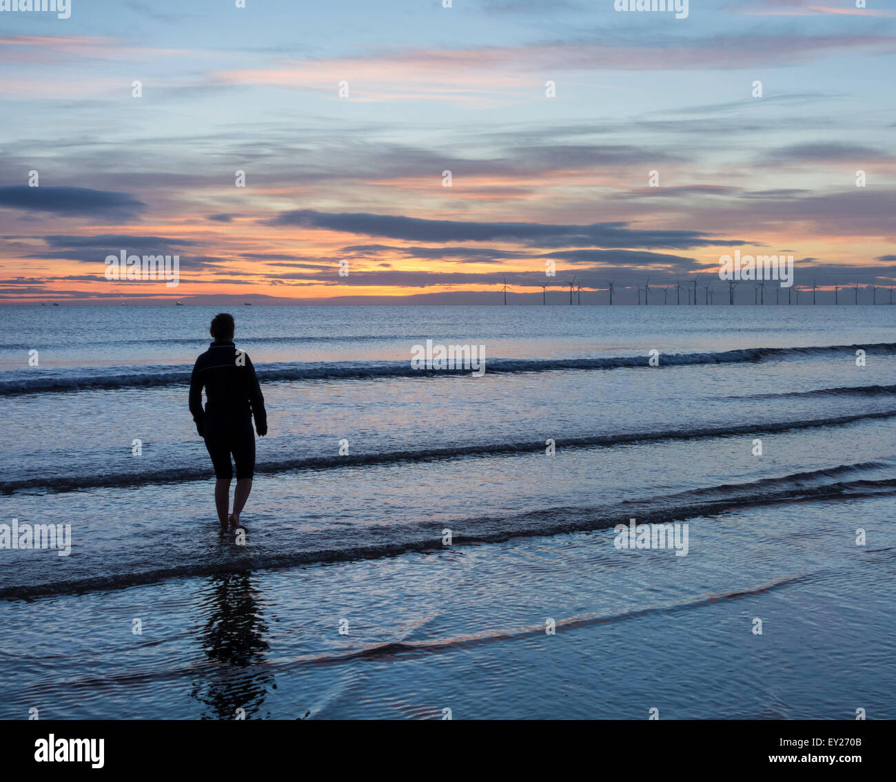 Weibliche Jogger Abkühlung nach bei Sonnenaufgang am Strand laufen. UK Stockfoto