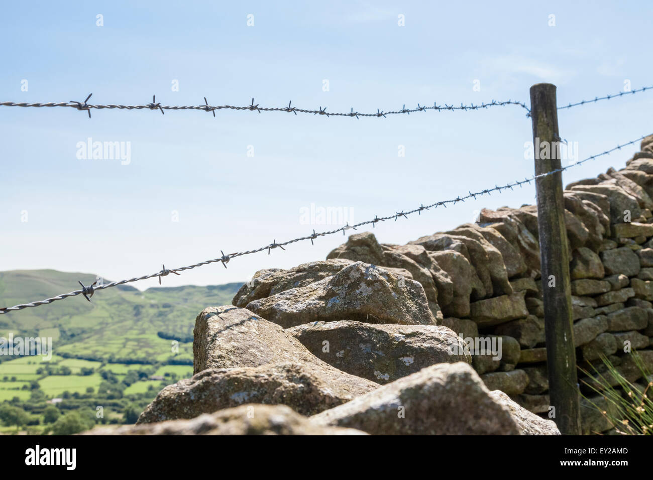 Trockenmauer (oder trockenmauern Wand) mit Stacheldraht entlang der Oberseite, Derbyshire, Peak District National Park, England, Großbritannien Stockfoto