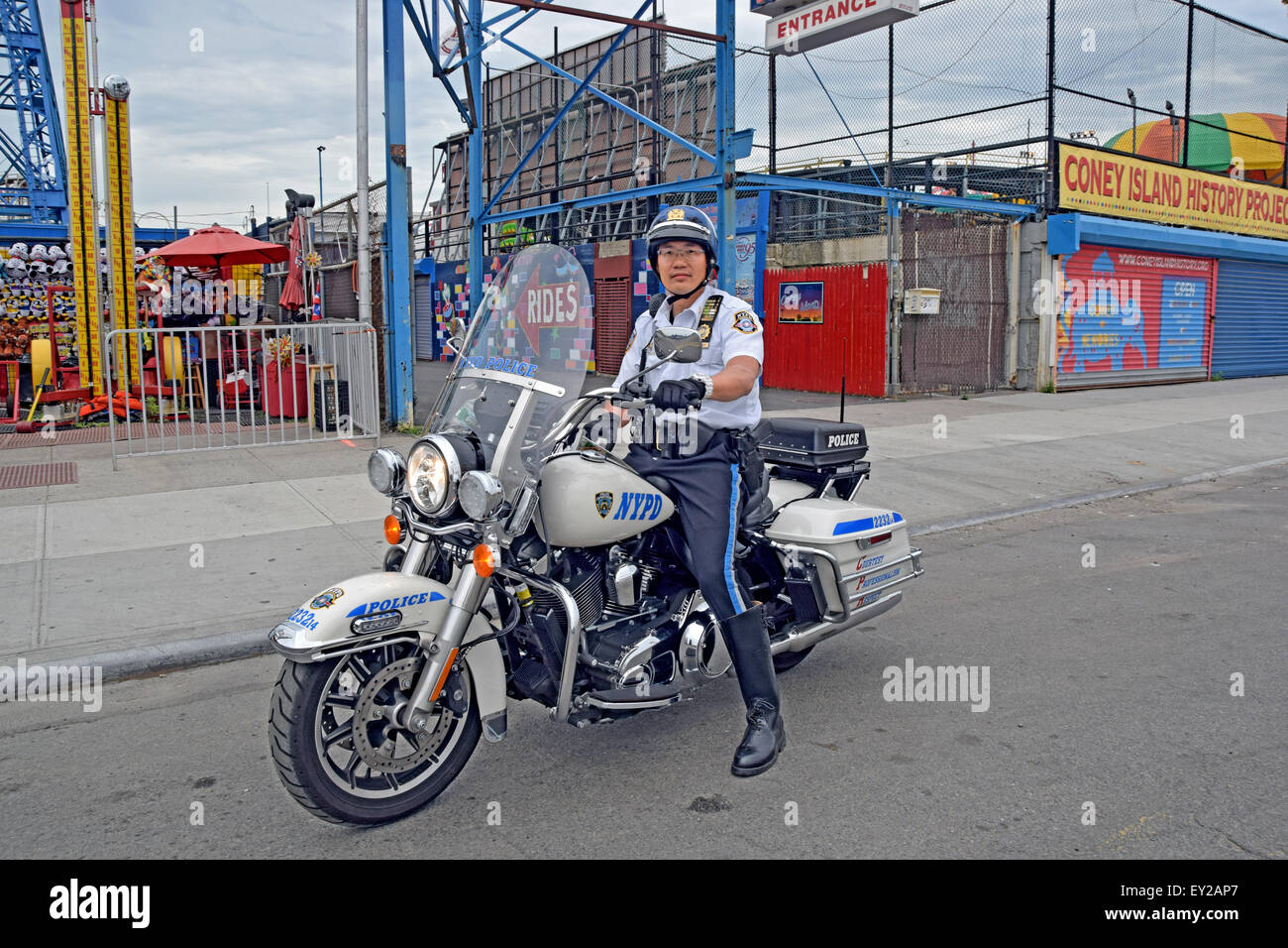 Ein asiatisch-amerikanische Polizisten patrouillieren auf einer Harley Davidson in Coney Island, Brooklyn, New York Stockfoto