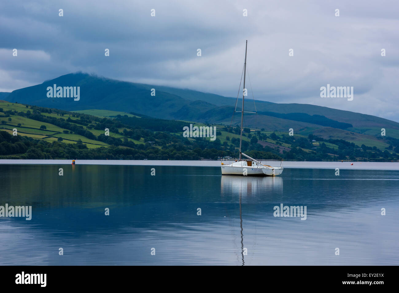 Bala Lake einzelne weiße Segelboot hoher Mast und Berge in der Ferne Nordwales Snowdonia National Park UK Juli 2015 Stockfoto