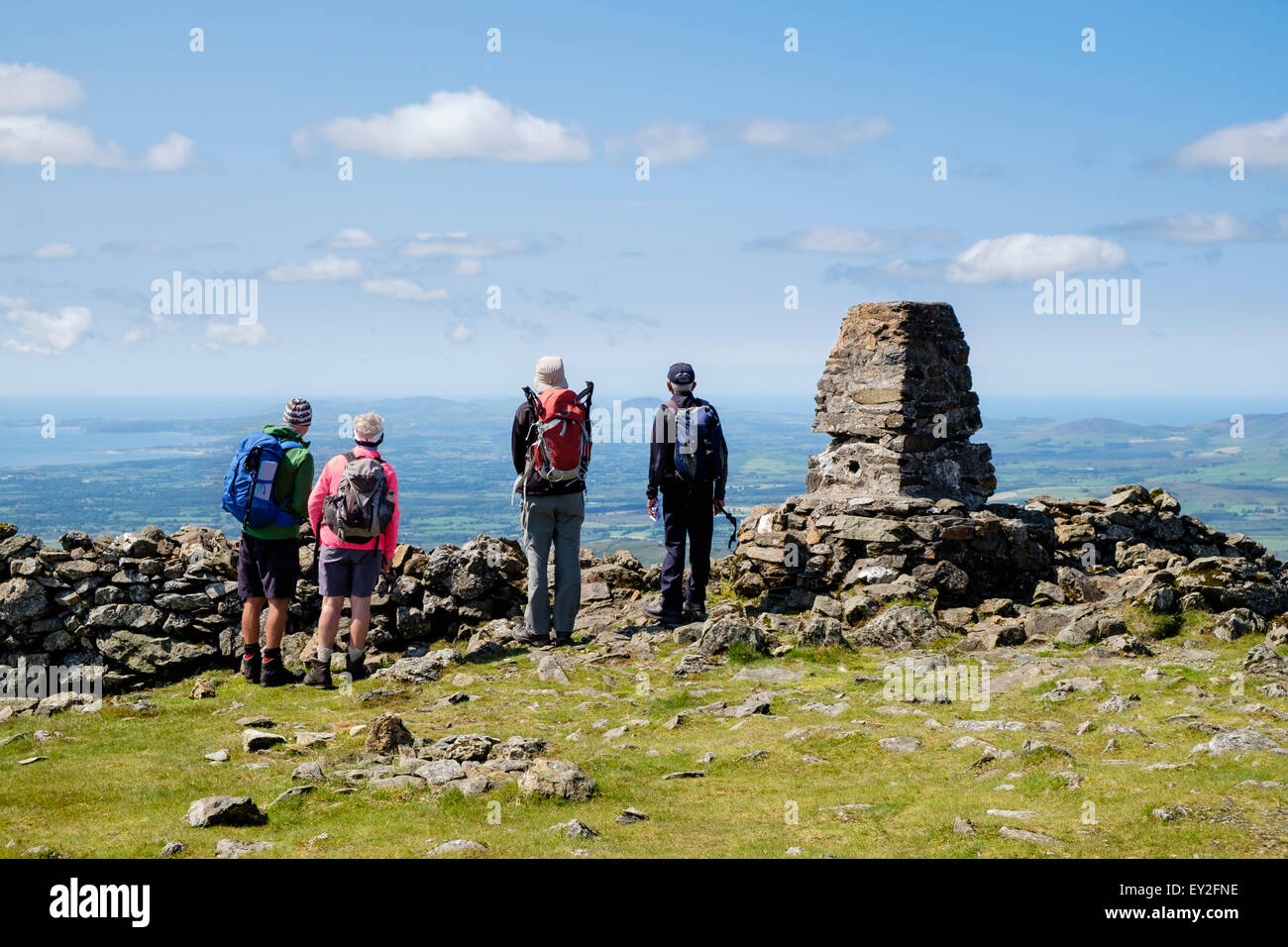Vier Wanderer, Blick nach Westen auf den Blick von trigonometrischen Punkt Cairn auf Moel Hebog Berggipfel in Berge von Snowdonia Wales UK Stockfoto