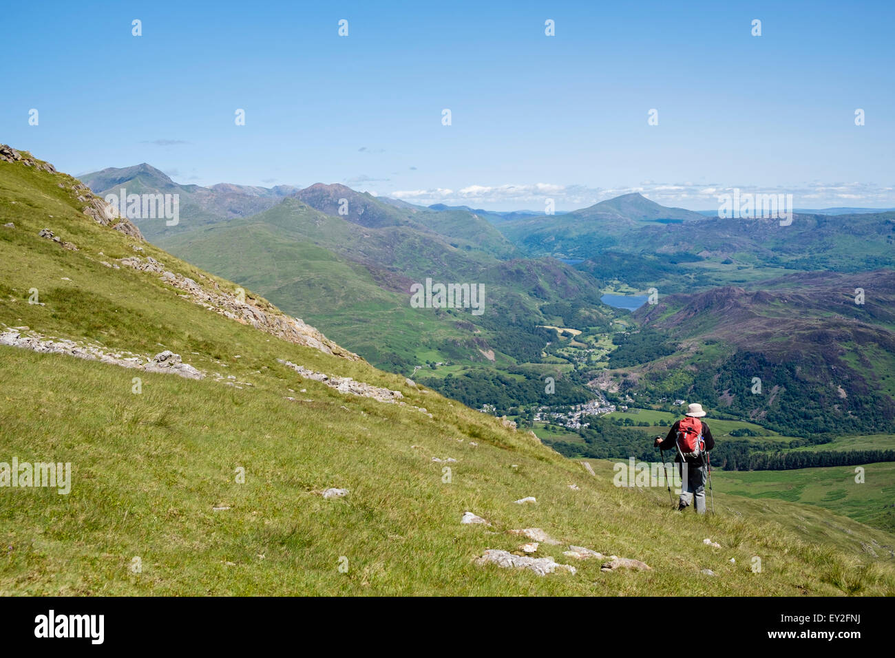 Einsamer Wanderer absteigend Moel Hebog Berg allein Wandern in den Bergen von Snowdonia National Park mit Fernsicht zu Beddgelert Wales UK Stockfoto