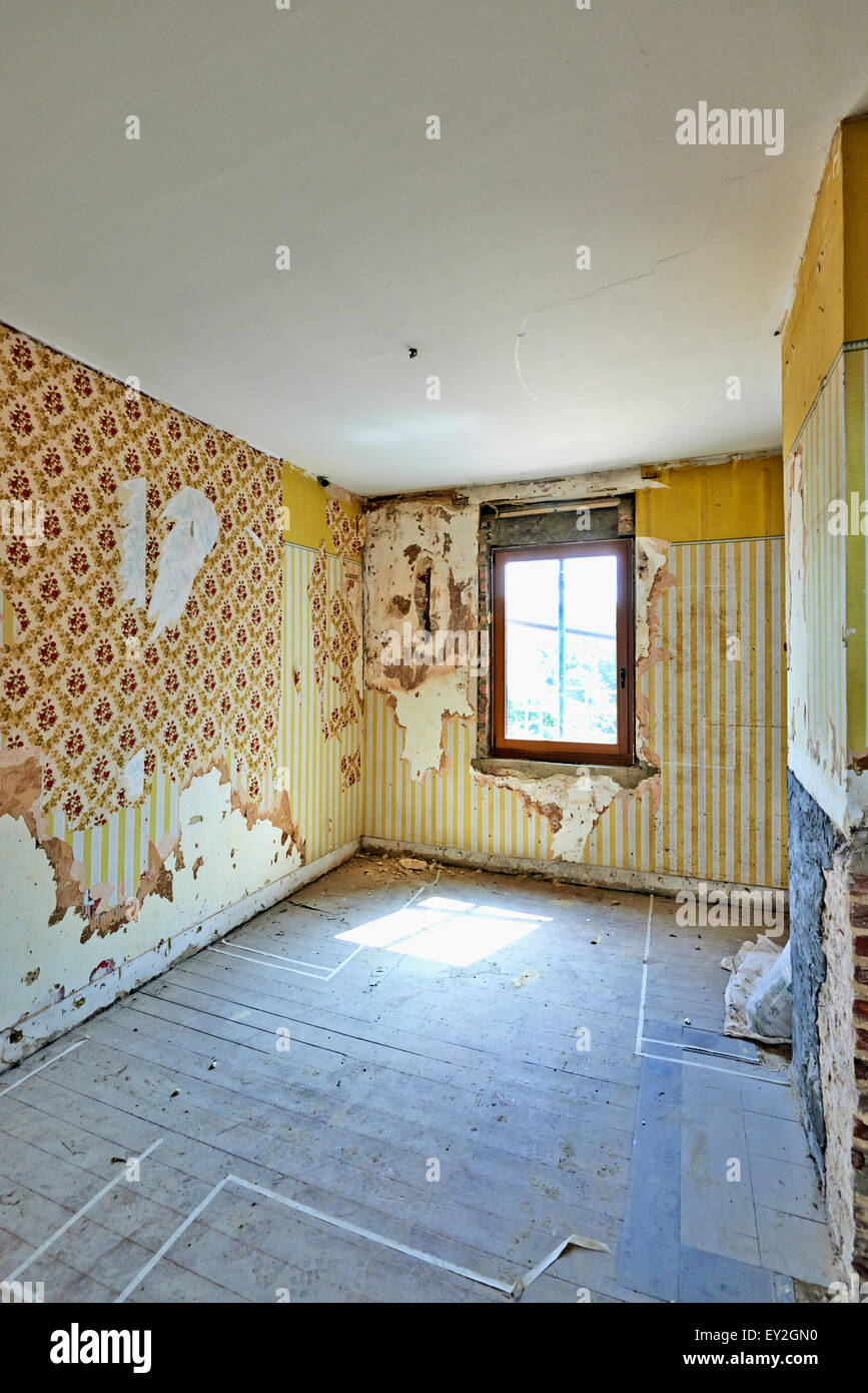 Verlassene Zimmer mit Vintage und Grunge strukturierte Tapeten vor dem Umbau. Stockfoto